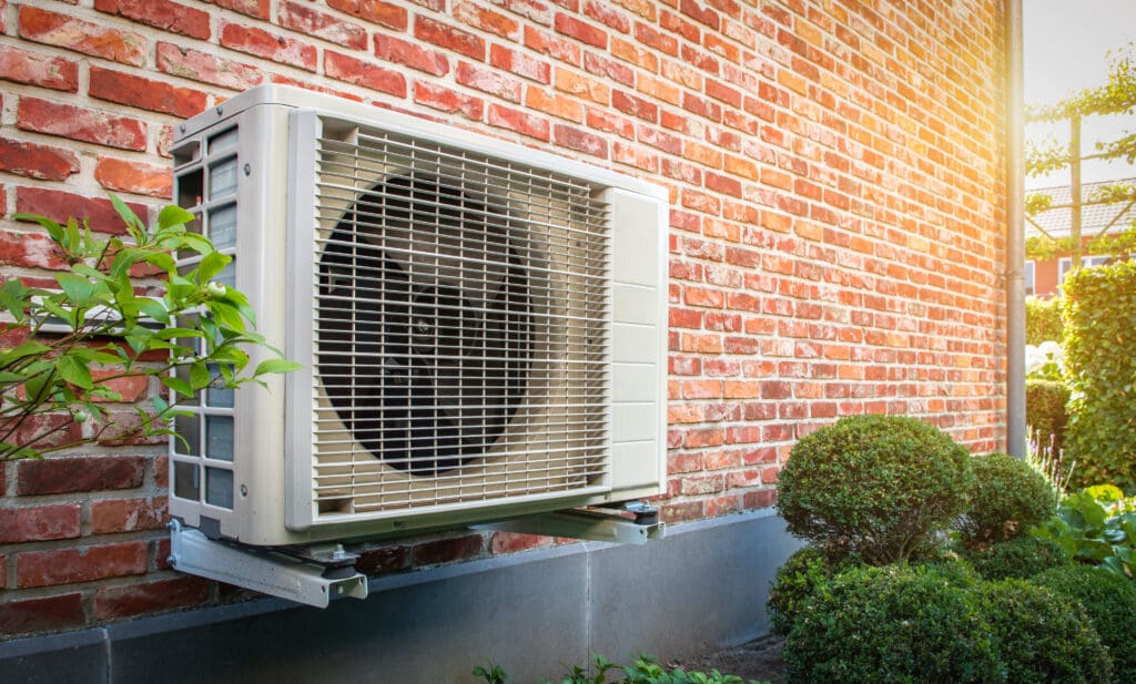 Outdoor heat pump unit connected to the brick house exterior