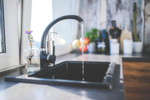 a kitchen sink with water running from the faucet